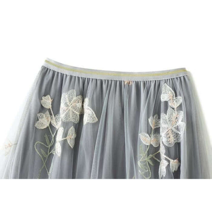 Elegant gray tulle skirt with delicate floral embroidery, perfect for stylish and comfortable summer outfits.