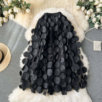 Large black circle embellished midi skirt, stylish and chic, perfect for romantic occasions and versatile wardrobe styling.