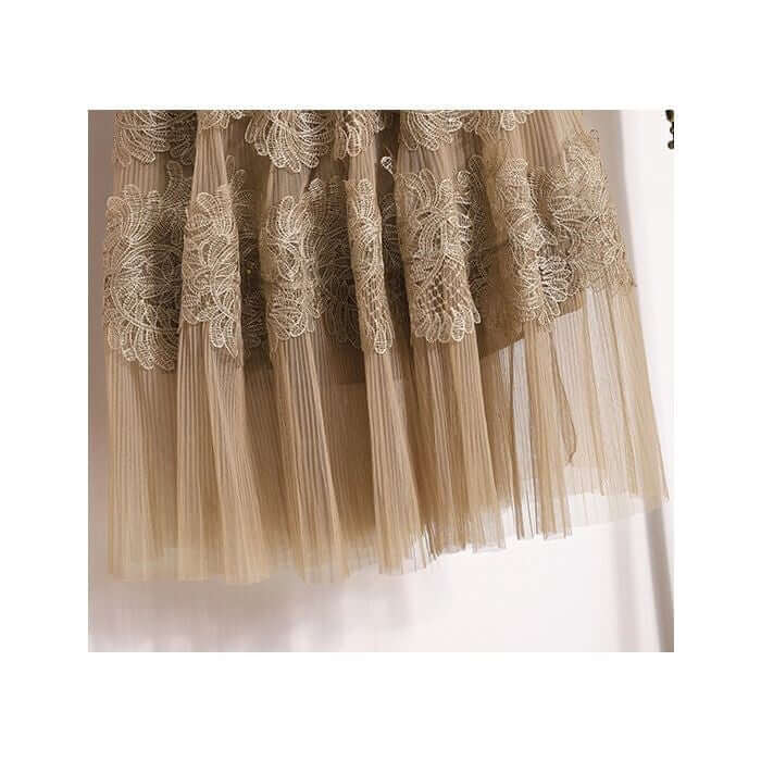 Elegant layered tulle midi skirt with intricate lace detailing in a soft beige color.