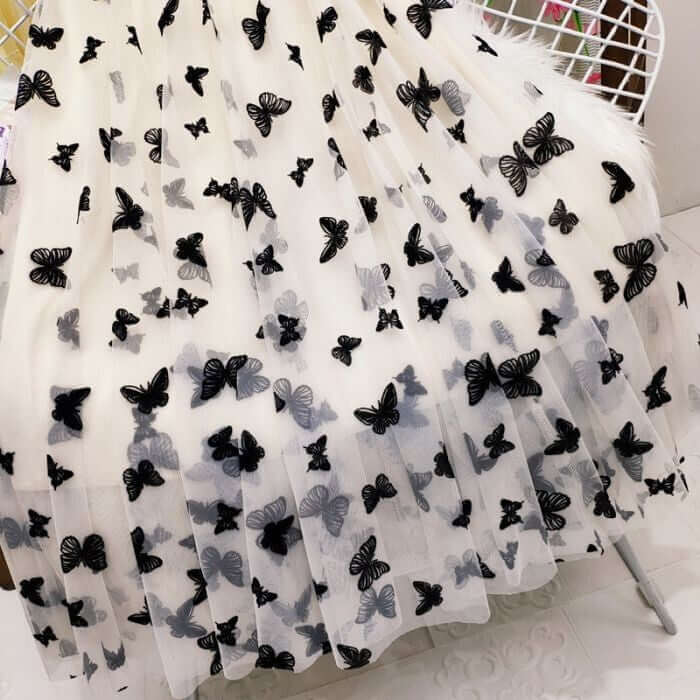 Elegant white mesh skirt with black 3D butterfly prints, stylish and chic design for women's fashion.