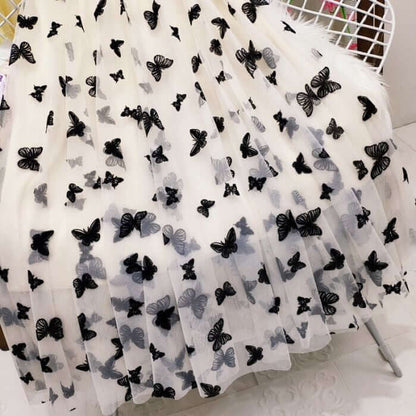 Elegant white mesh skirt with black 3D butterfly prints, stylish and chic design for women's fashion.