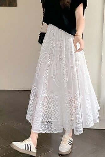 Woman wearing a stylish white lace maxi skirt with sneakers, showcasing a chic and comfortable look.