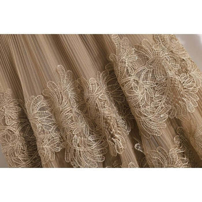 Close-up of intricate lace detailing on a flowy tulle skirt, showcasing elegance and style.