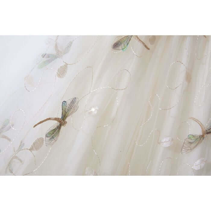 Delicate embroidered dragonfly pattern on soft tulle fabric for stylish midi skirts, perfect for summer collections.
