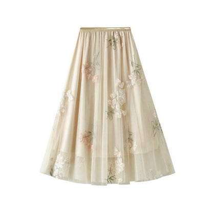 Elegant layered tulle maxi skirt in soft beige with floral embroidery, perfect for summer wardrobes.