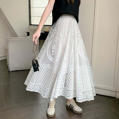 White lace maxi skirt with layered design, styled with a black top and sneakers for a chic and casual look.