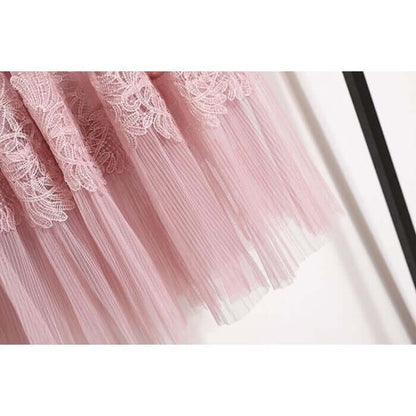 Close-up of a pink lace and tulle midi skirt, showcasing elegant layered details and delicate floral embroidery.
