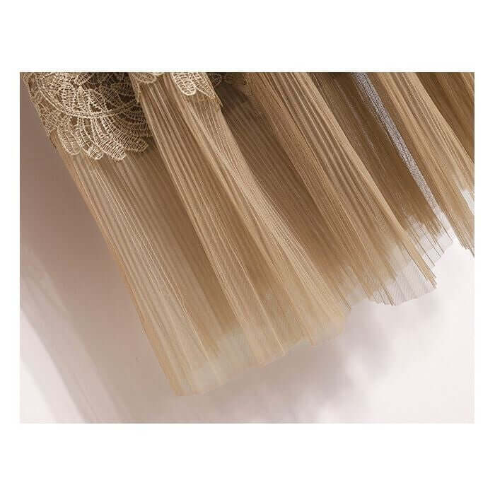 Close-up of elegant beige lace and tulle pleated midi skirt showcasing delicate layers and intricate lace detailing.