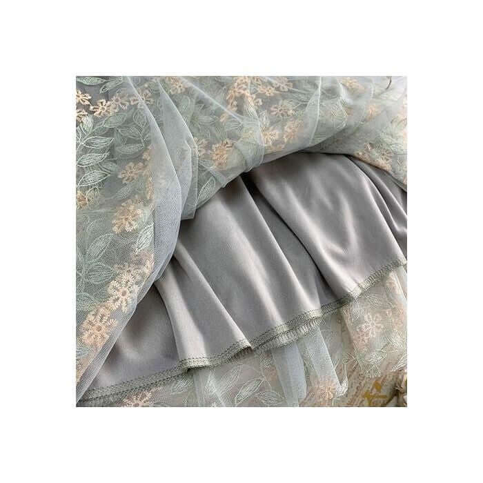Elegant layered tulle fabric with floral embroidery and smooth satin for stylish midi women's skirts.