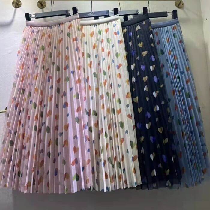 Hearts pattern pleated midi skirts in pink, white, and blue, showcasing a stylish and chic design for women.