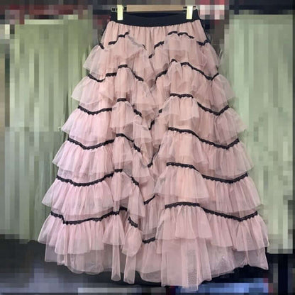 Elegant layered pink tulle midi skirt with ruffles and black trim for stylish summer outfits.